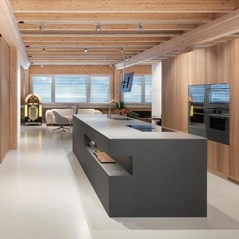 Küche nach Mass mit modernem Design und Holzoptik Moderne Küche nach Mass mit grauer Kücheninsel, Holzverkleidung, integrierten Geräten und sichtbaren Deckenbalken.