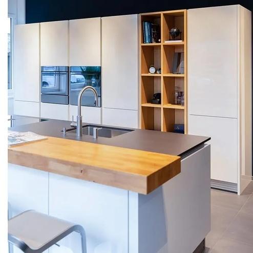 Moderne Küche mit Holz- und Hochglanzelementen Küche mit integriertem Regal in Holzoptik, Hochglanzfronten, moderner Spüle und Arbeitsplatte aus kontrastierenden Materialien.