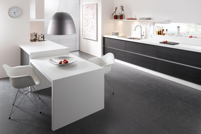 Impression einer einzeiligen Küchengestaltung in schwarz-weiss mit Esstisch für Zwei