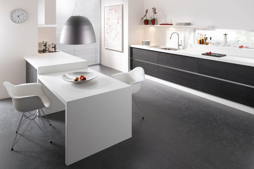 Impression einer einzeiligen Küchengestaltung in schwarz-weiss mit Esstisch für Zwei