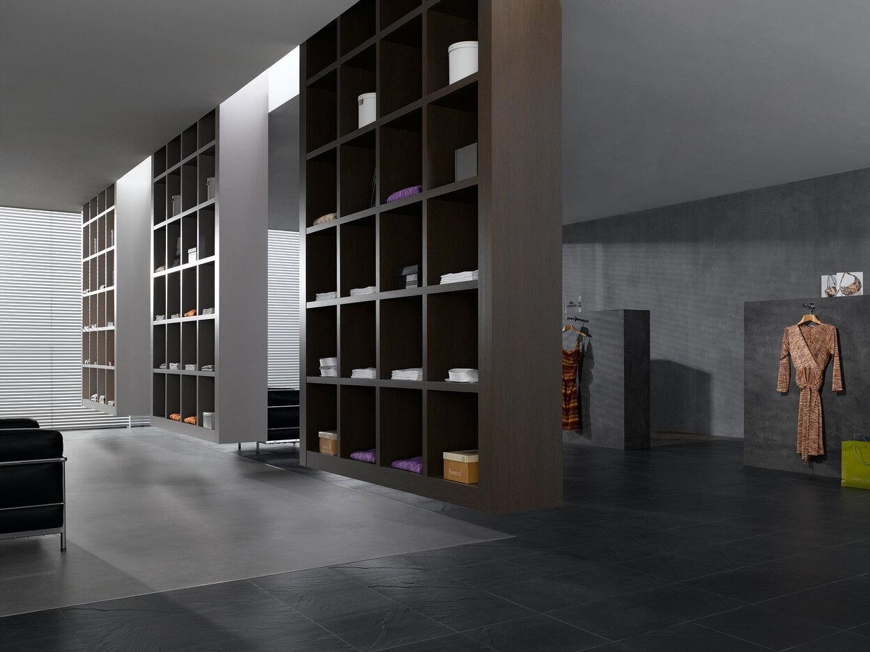 Impression eines geräumigen Regalsystems aus dunklem Holz in einem hochwertigen Bekleidungsladen