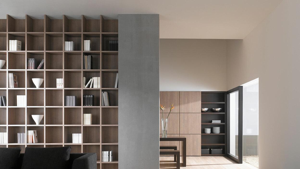 Offene Wohnraumimpression mit Einbauregal in Trennwand Offene Wohnraumimpression mit Einbauregal für Bücher und Dekoration in Trennwand mit hellem Holzboden