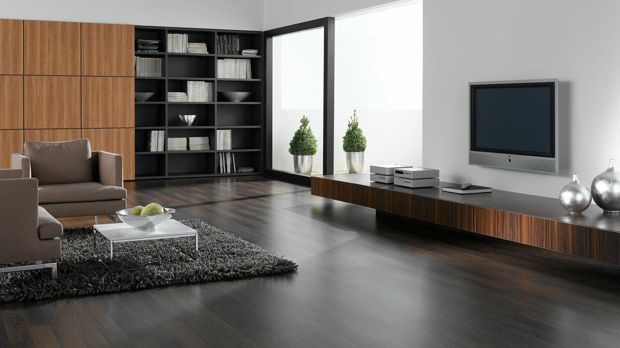 Wohnraumimpression mit verschieden dunklen Holzoberflächen für Einbauschrank, Sideboard und Bodenbelag