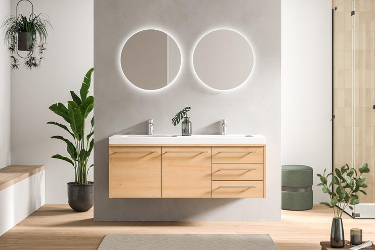 Zweckmässig designtes Bad nach Mass mit hellem Holzschrank, zwei runden Spiegeln und einer atmosphärischen Beleuchtung, die Ruhe ausstrahlt.