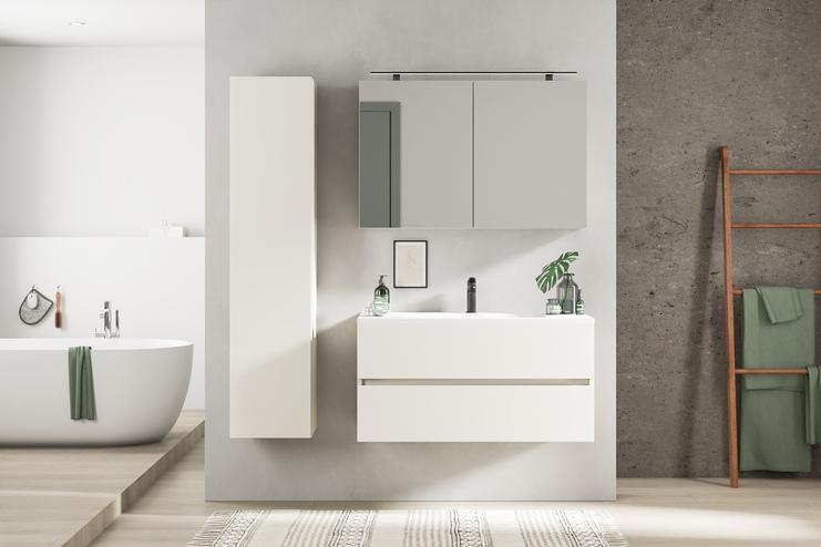 Massgefertigtes Bad mit schlichtem weissen Waschtisch, Spiegelschrank und betonfarbenen Wänden für einen modernen, puristischen Look.