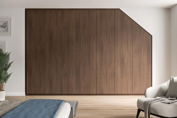 Massgefertigter, dunkelbrauner Schrank, der sich harmonisch in die Schräge eines stilvollen Schlafzimmers einfügt.