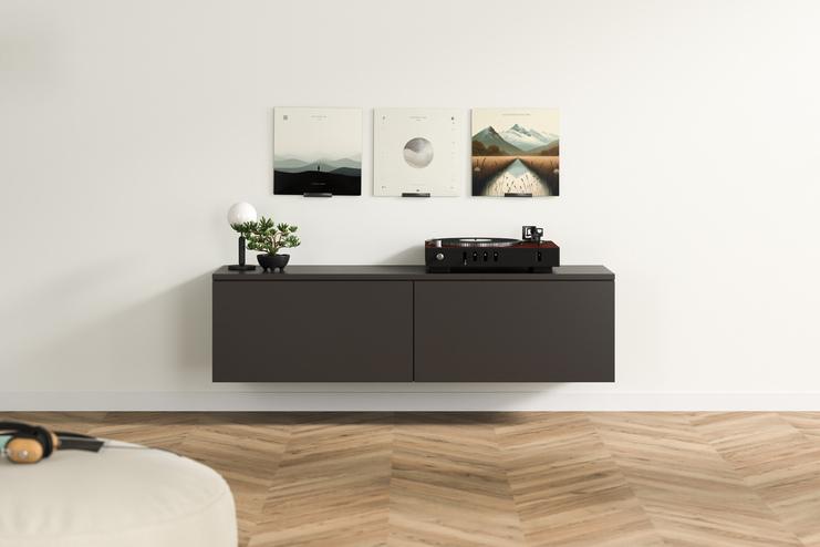 Dunkelgraues, massgefertigtes Hängeboard mit klaren Linien und Plattenspieler, akzentuiert durch eine Pflanze und kunstvolle Bilder an der Wand darüber.